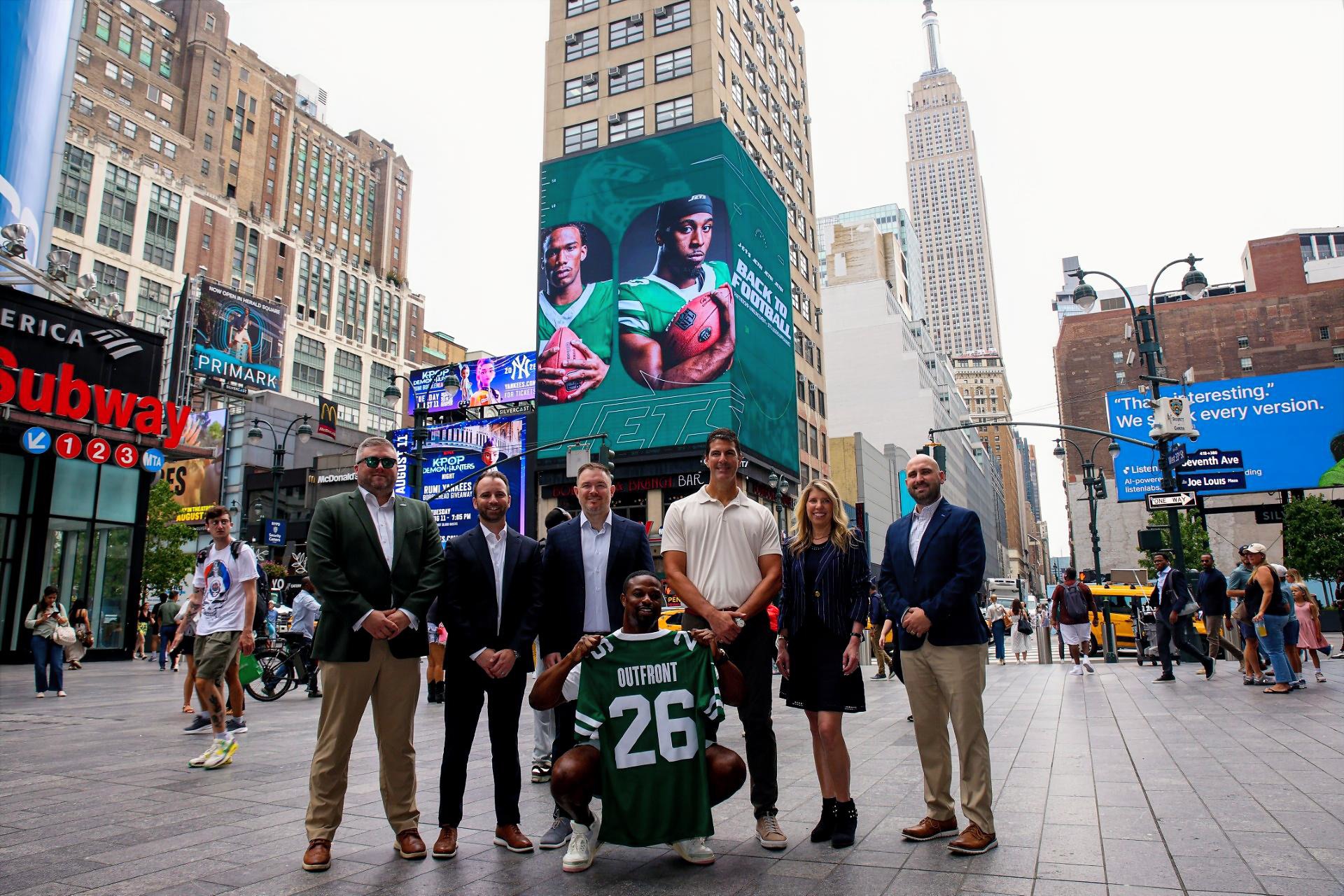 Representatives from Outfront and the New York Jets celebrate their new multi-year partnership (Image: Outfront)